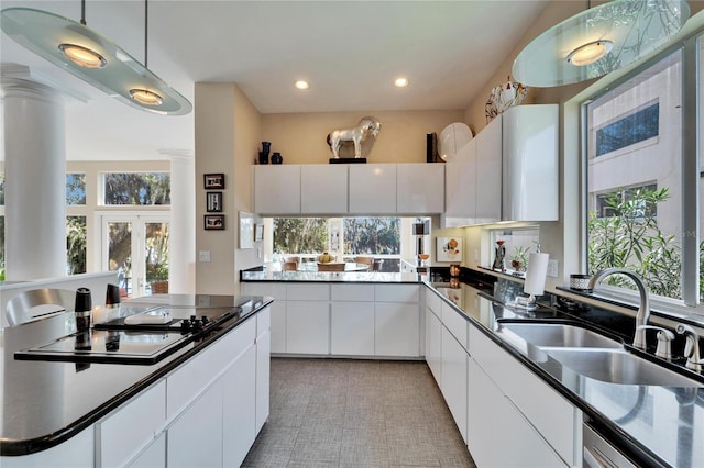 kitchen with pendant lighting, sink, french doors, and white cabinets