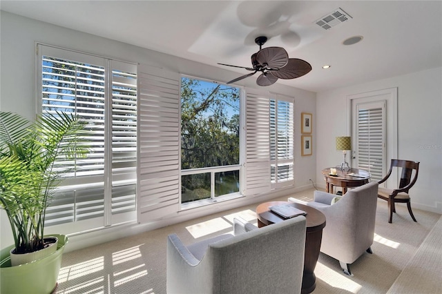 living room with light colored carpet and ceiling fan