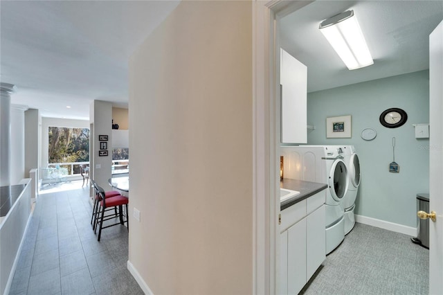 clothes washing area featuring decorative columns and washer and dryer