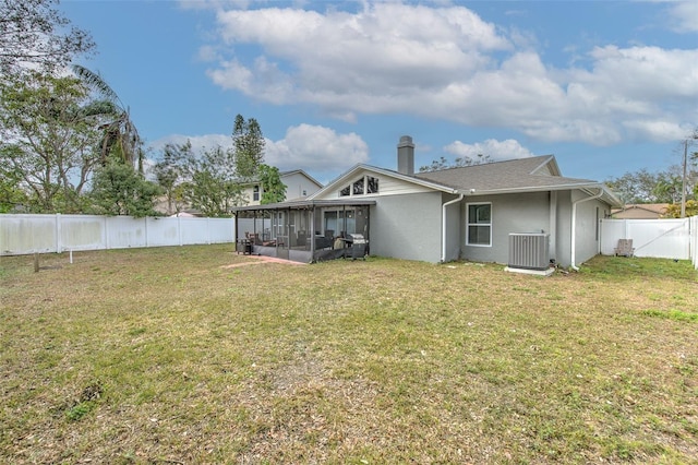 back of house with a lawn, a sunroom, and central air condition unit