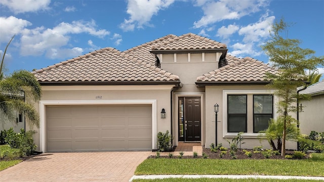 mediterranean / spanish-style house featuring a garage and a front yard