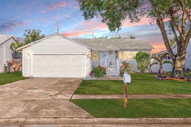 ranch-style house featuring driveway, an attached garage, and a yard