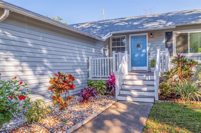 property entrance with a shingled roof