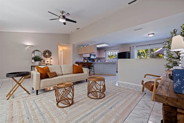 living area featuring visible vents, marble finish floor, a ceiling fan, baseboards, and vaulted ceiling