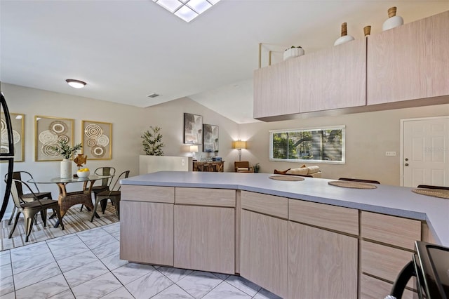 kitchen with light brown cabinets, a peninsula, lofted ceiling, light countertops, and marble finish floor