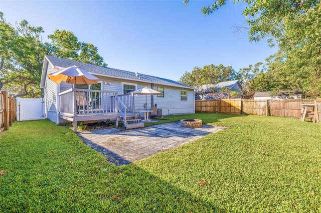 rear view of house featuring a fire pit, a fenced backyard, a lawn, and a patio area