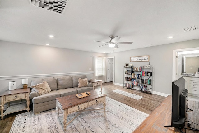 living room featuring ceiling fan and hardwood / wood-style floors