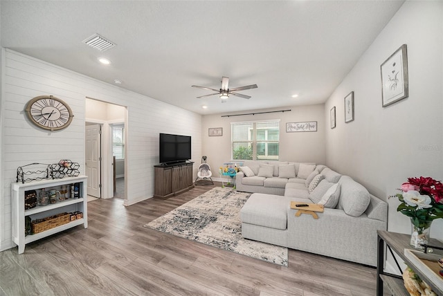 living room featuring ceiling fan and light hardwood / wood-style floors