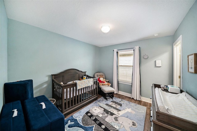 bedroom featuring hardwood / wood-style floors and a crib