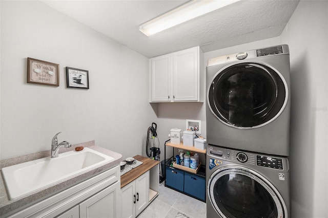 laundry area featuring cabinets, stacked washing maching and dryer, sink, and light tile patterned floors