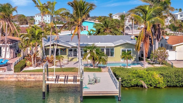 back of property with a water view and a patio