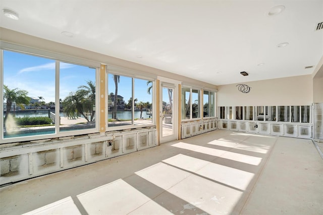 sunroom featuring a water view and a healthy amount of sunlight