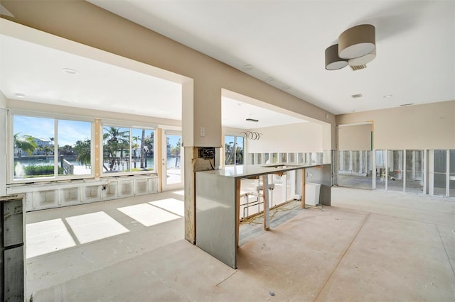 interior space featuring a water view, ceiling fan, and an outdoor bar