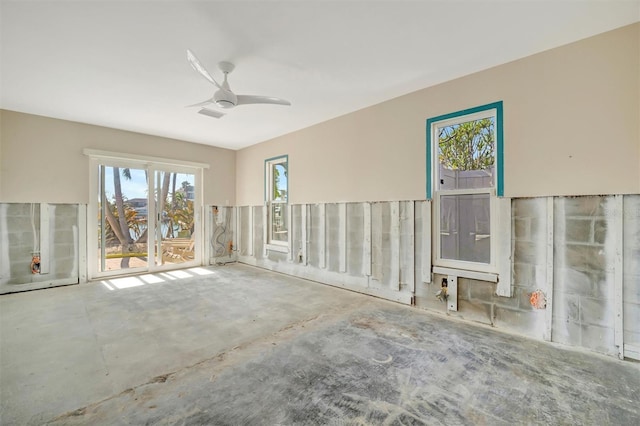 empty room with concrete floors and ceiling fan