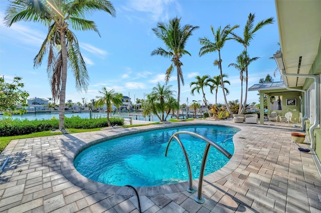 view of swimming pool featuring a water view and a patio area