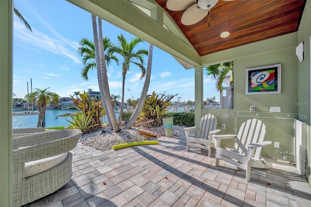 view of patio featuring ceiling fan and a water view