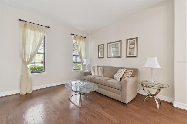 living area featuring dark wood-type flooring and baseboards