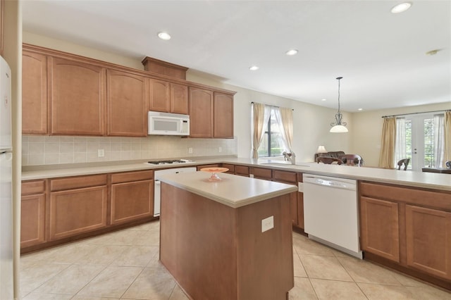 kitchen featuring brown cabinets, white appliances, and light countertops