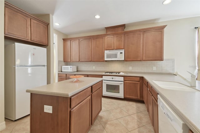 kitchen with white appliances, a sink, light countertops, tasteful backsplash, and brown cabinetry