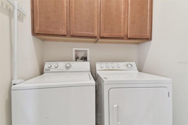 clothes washing area featuring cabinet space and washing machine and clothes dryer