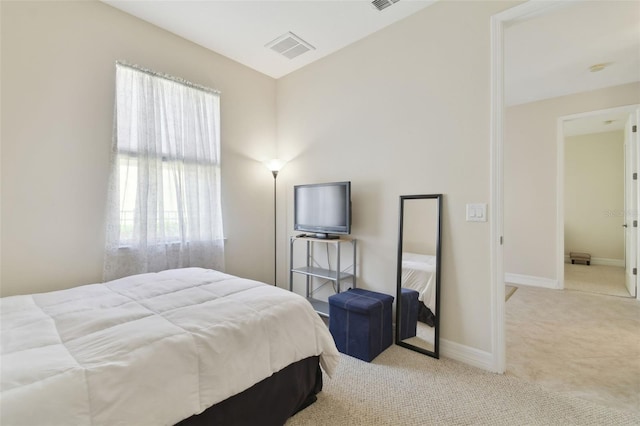 bedroom with light carpet, visible vents, and baseboards