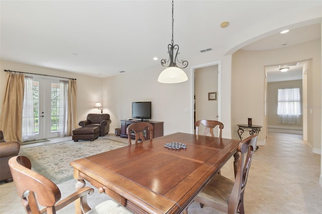 dining area featuring arched walkways, light tile patterned floors, recessed lighting, visible vents, and french doors