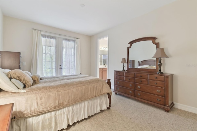 bedroom with french doors, light carpet, ensuite bath, and baseboards