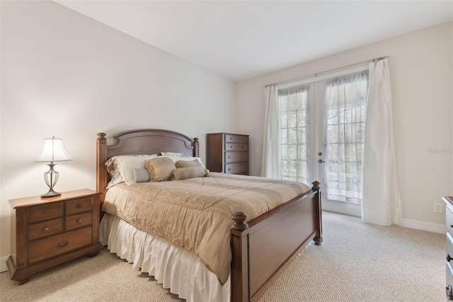 bedroom featuring access to outside, french doors, light carpet, and baseboards