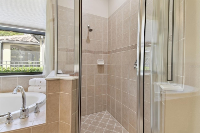 bathroom with a stall shower and a garden tub