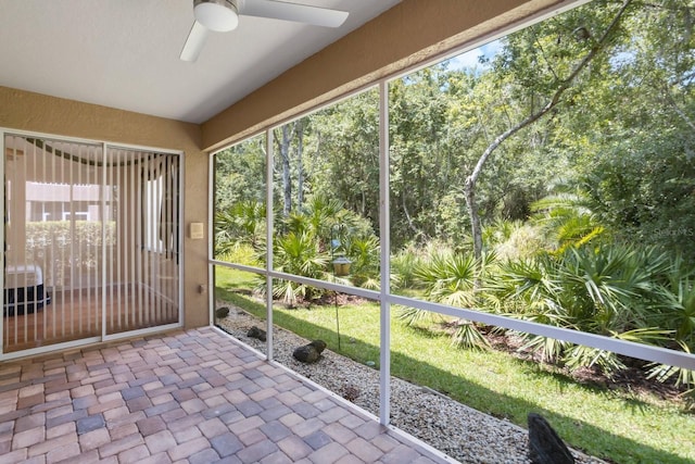 unfurnished sunroom featuring a healthy amount of sunlight and ceiling fan