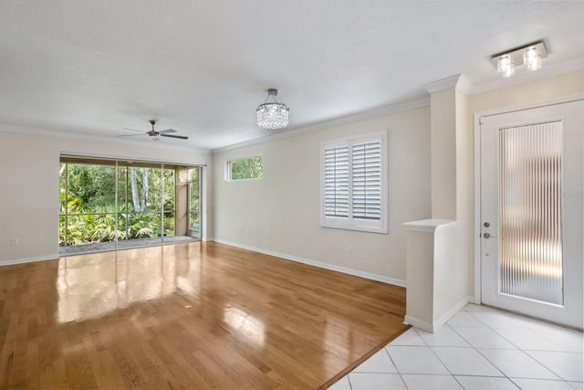 foyer entrance featuring crown molding, ceiling fan, and light wood-type flooring