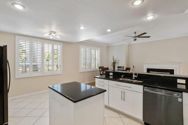 kitchen with white cabinetry, sink, a kitchen island with sink, light tile patterned floors, and stainless steel appliances