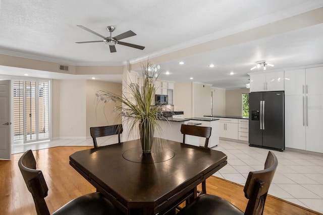 tiled dining area with a wealth of natural light, ornamental molding, and a textured ceiling