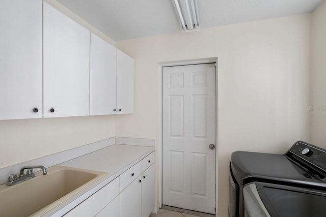 laundry room featuring cabinets, sink, and washing machine and clothes dryer