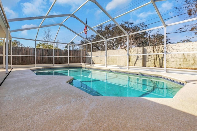 view of swimming pool featuring a lanai and a patio