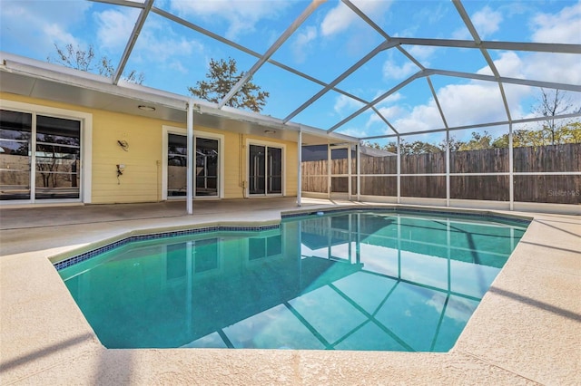 view of swimming pool with glass enclosure and a patio area