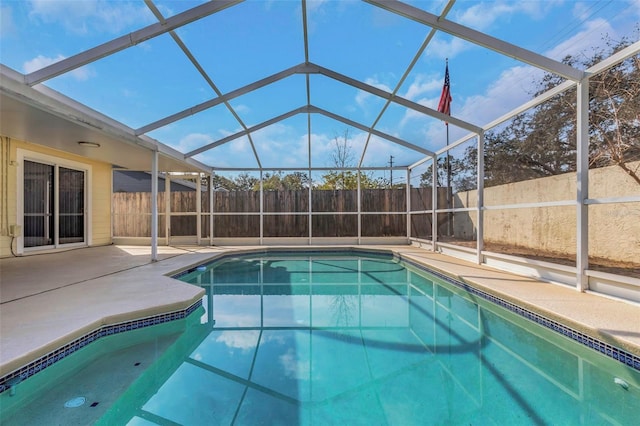 view of swimming pool featuring a patio and glass enclosure