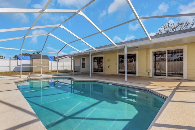 view of swimming pool with a storage shed, a lanai, and a patio