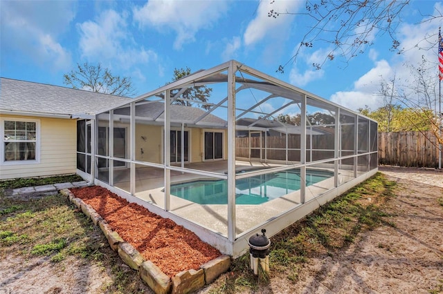 exterior space with a fenced in pool, a patio, and glass enclosure