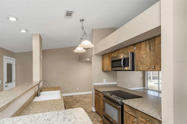 kitchen with light tile patterned flooring, sink, pendant lighting, a textured ceiling, and range with electric cooktop