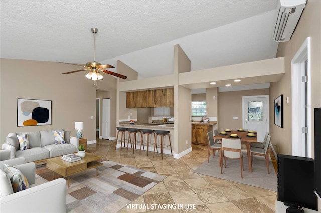 living room featuring ceiling fan, high vaulted ceiling, an AC wall unit, and a textured ceiling