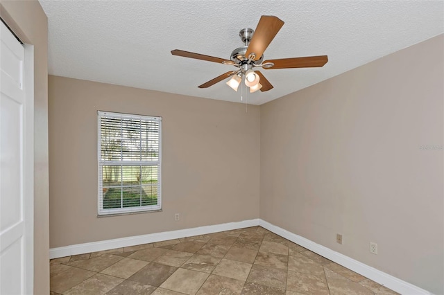 unfurnished room with ceiling fan and a textured ceiling