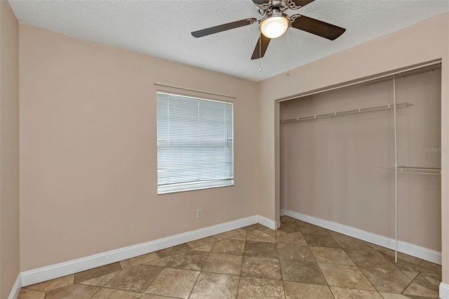 unfurnished bedroom featuring ceiling fan, a textured ceiling, and a closet