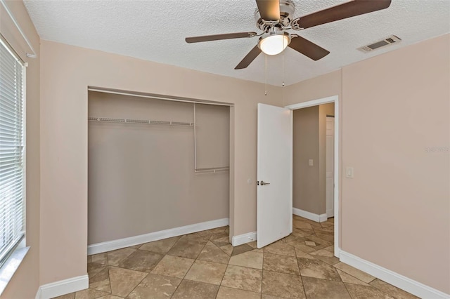 unfurnished bedroom featuring a textured ceiling, a closet, and ceiling fan