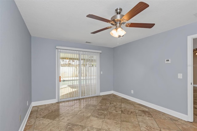 empty room with ceiling fan and a textured ceiling