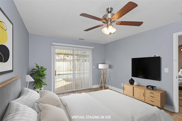 bedroom with ceiling fan, a textured ceiling, and access to outside