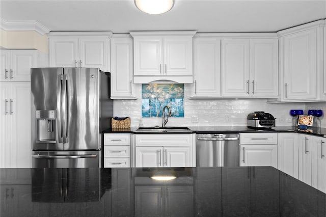 kitchen with stainless steel appliances, sink, white cabinets, and decorative backsplash