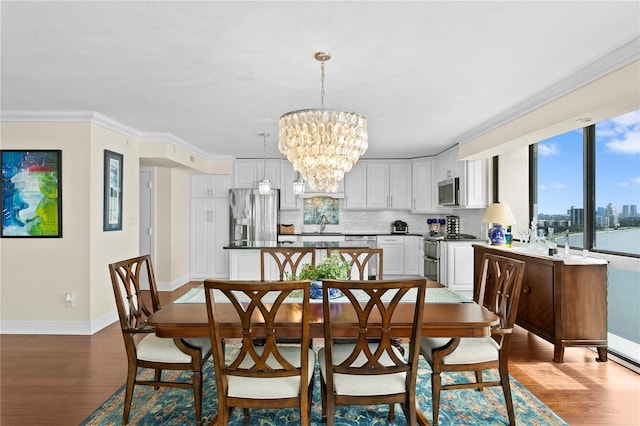 dining area featuring an inviting chandelier, hardwood / wood-style flooring, and ornamental molding