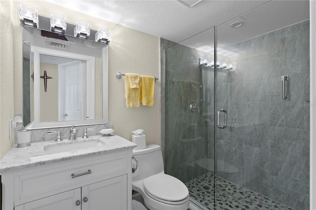 bathroom featuring vanity, a textured ceiling, a shower with shower door, and toilet