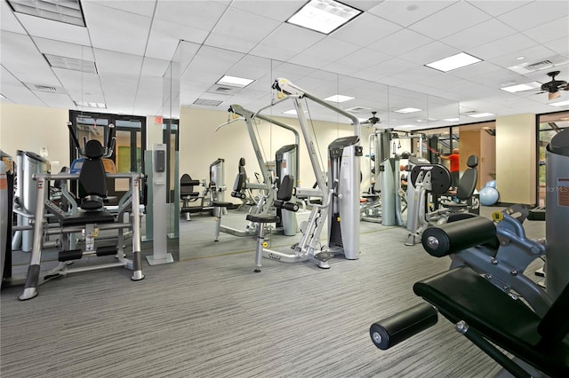 gym with a drop ceiling and carpet